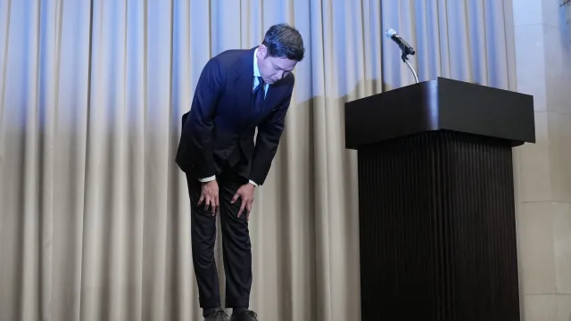 Shinsegae Group chairman bowing deeply at podium in public apology following Starbucks Korea Tank Day cultural intelligence failure